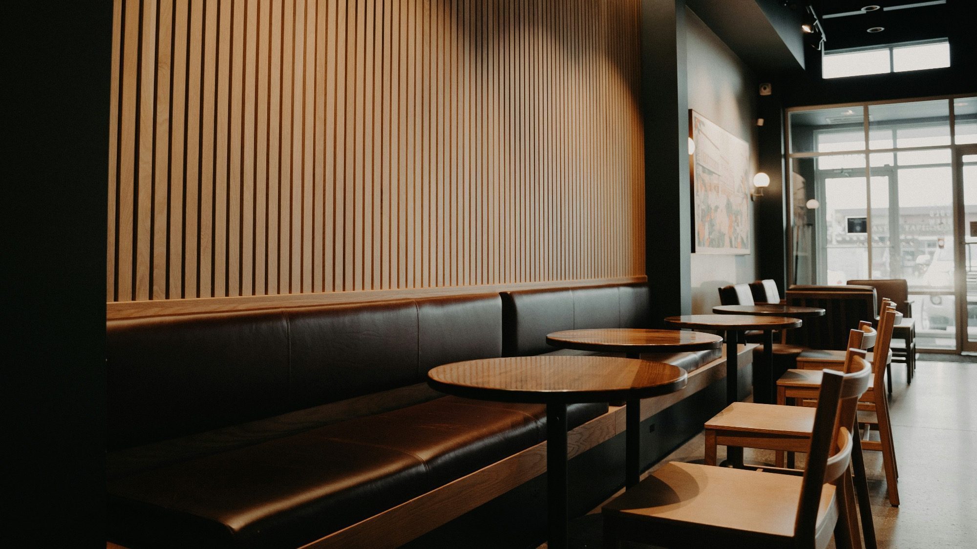 The quiet cafe, reminiscent of a Starbucks with its wooden walls, round tables, and chairs neatly arranged by the large window, awaits the buzz of customers post a recent performance.